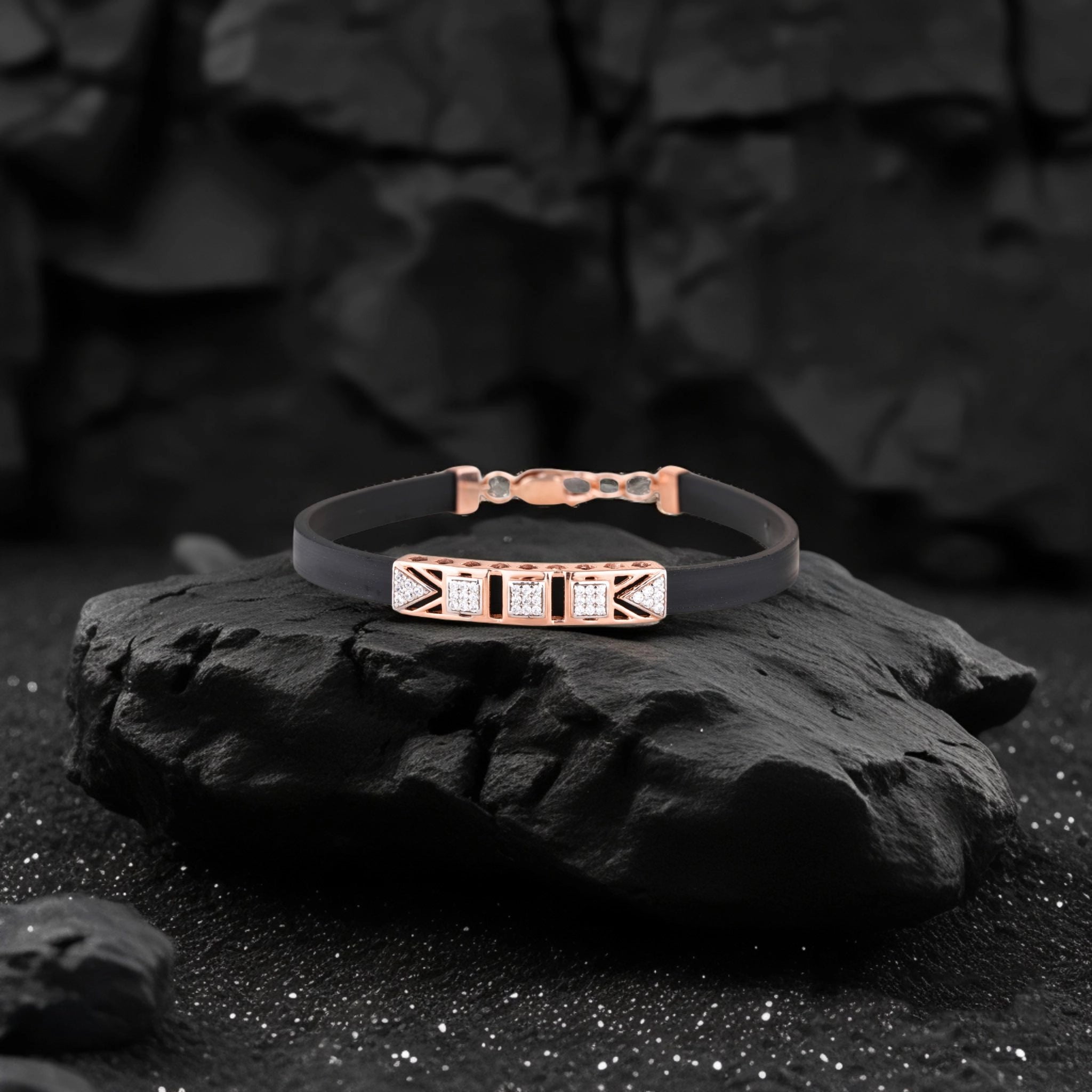 Black bracelet with rose gold accents on a dark stone surface