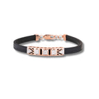 Black bracelet with rose gold and diamond accents on a white background