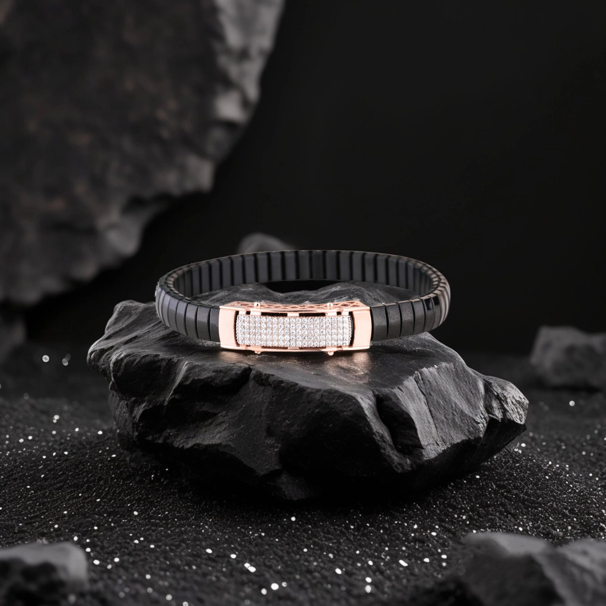 Black bracelet with rose gold clasp on a dark stone surface