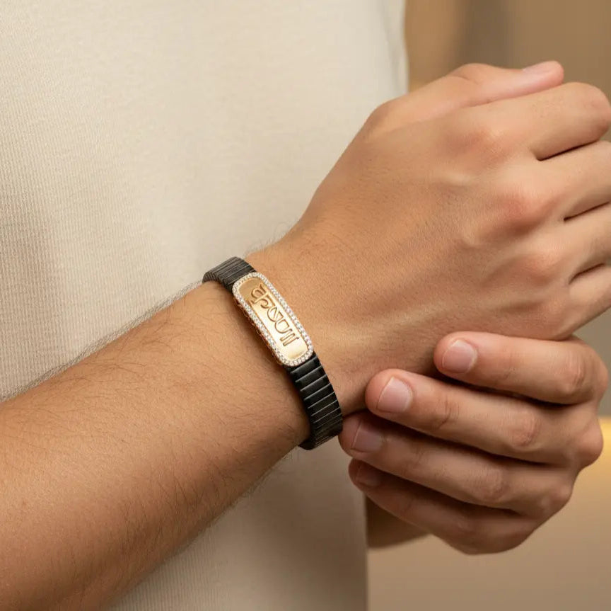 Person wearing a bracelet with a visible brand logo on a neutral background