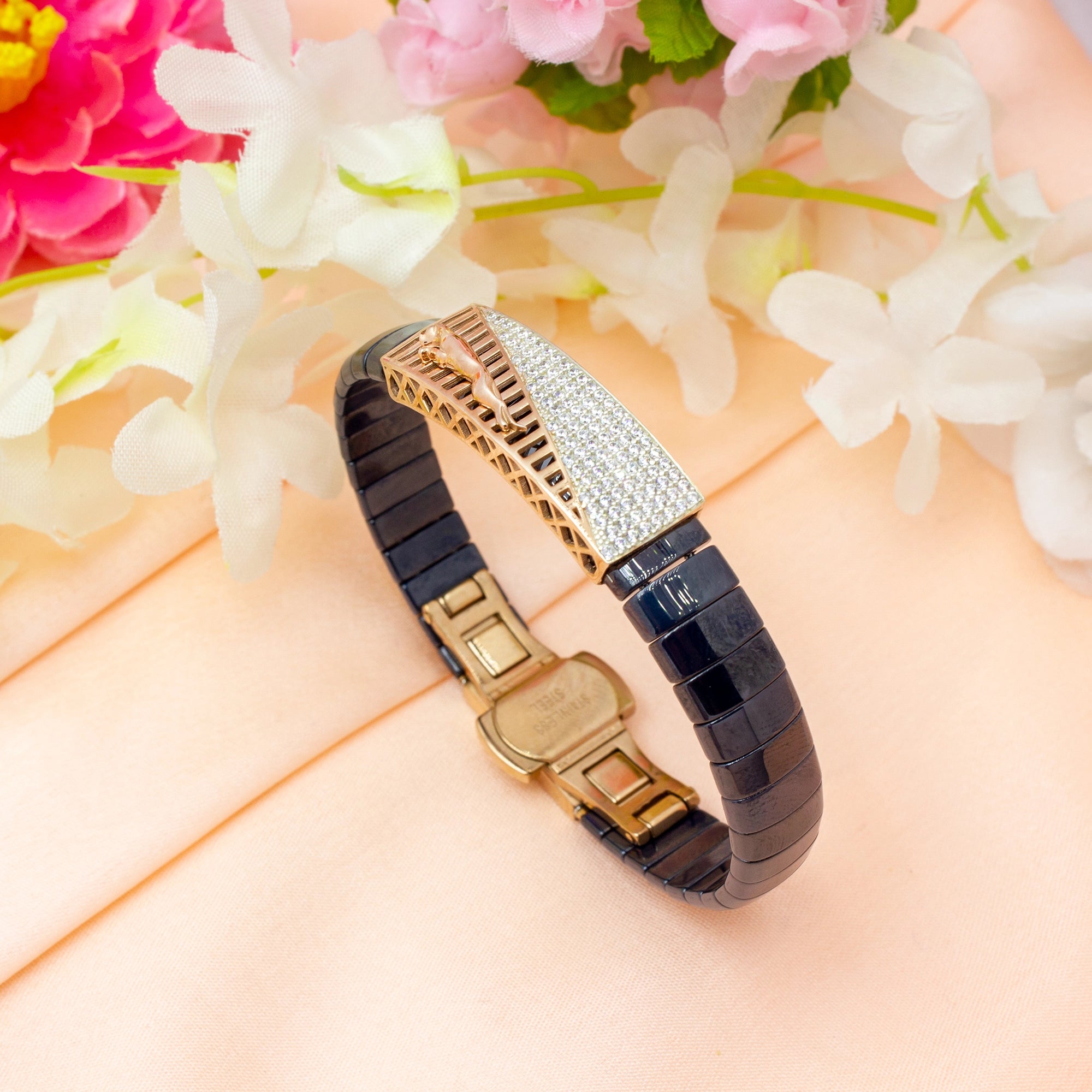 Decorative bracelet with gold and black design on a floral background