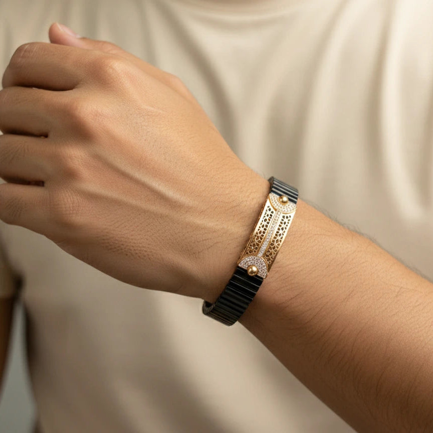 Close-up of a wrist wearing a black bracelet with a diamond on a neutral background