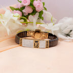 Luxury bracelet with brand logo on a pink surface with flowers