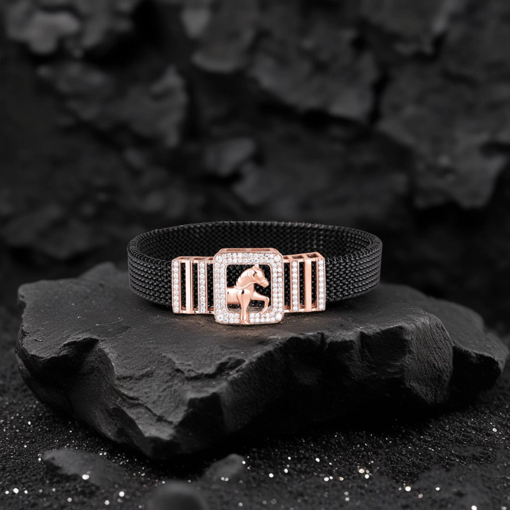 Black bracelet with a rose gold clasp featuring a horse design on a dark stone surface.