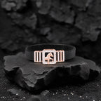 Black bracelet with a rose gold clasp featuring a horse design on a dark stone surface.