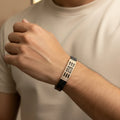 Person wearing a stylish bracelet on a neutral background