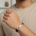 Men’s black and silver bracelet with Greek key pattern worn on wrist – luxury Intentions Jewelry