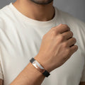 Rose gold geometric men’s imitation bracelet with black strap worn on wrist