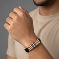 Rose gold striped men’s imitation bracelet with stone detailing worn on wrist