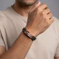 Rose gold vertical perforated men’s imitation bracelet with black band and emblem